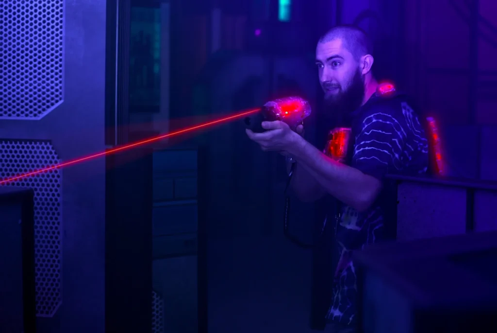 laser tag game player shooting light gun science fiction vest in black light